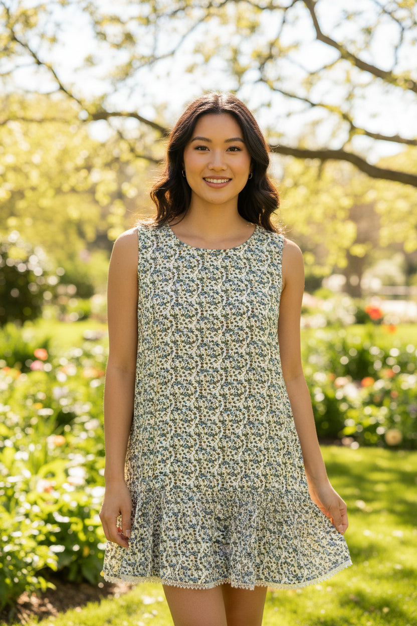 A sleeveless, high-low tiered dress with an all-over small floral print in blue, green, 